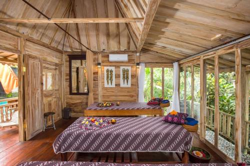 um quarto com 2 camas num quarto com paredes de madeira em Alas Petulu Villa Resort and Spa em Ubud