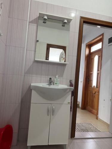 W łazience znajduje się biała umywalka i lustro. w obiekcie ВИЛА НАНО 