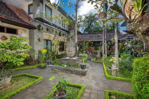 un jardín con una estatua en el medio en Alas Petulu Villa Resort and Spa, en Ubud