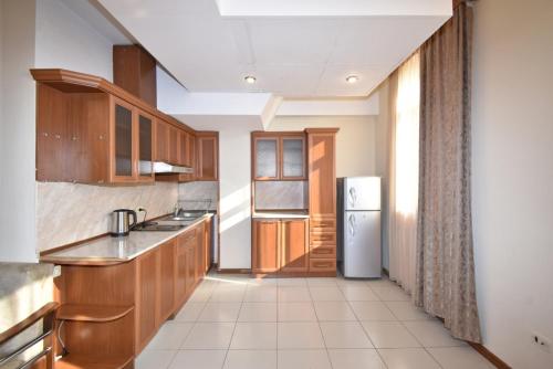 a kitchen with wooden cabinets and a refrigerator at Abovyan Street 16, Apartment No 24 in Yerevan