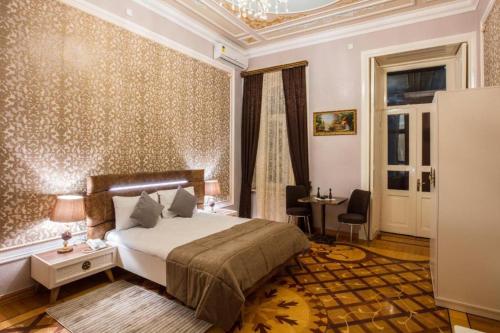 a bedroom with a bed and a table and chairs at Prestige Prime Hotel in Baku