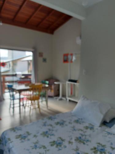 1 dormitorio con 1 cama, mesa y sillas en Loft Barra da Lagoa, en Florianópolis
