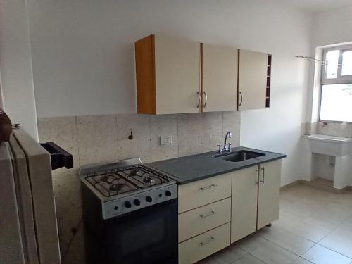 a kitchen with a stove and a sink at Departamento temporario in Salta