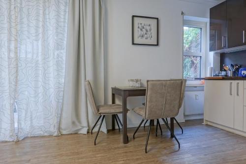 een keuken met een kleine tafel en 2 stoelen bij ruhige Ferienwohnung mitten in Wiesbaden in Wiesbaden