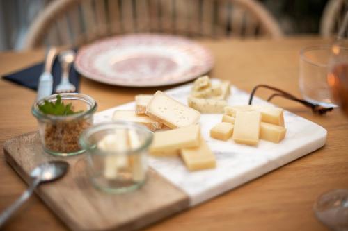 a plate of cheese on a wooden table at DAS SCHÖNE LEBEN Pop-Up Hotel in Hornberg