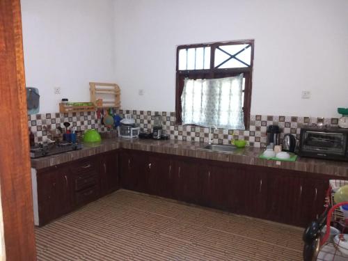 uma cozinha com balcões de madeira, um micro-ondas e uma janela em The Madampa Village Side Lodge em Ambalangoda
