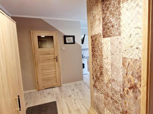 a hallway with a stone wall and a door at Old Town Room Ełk in Ełk