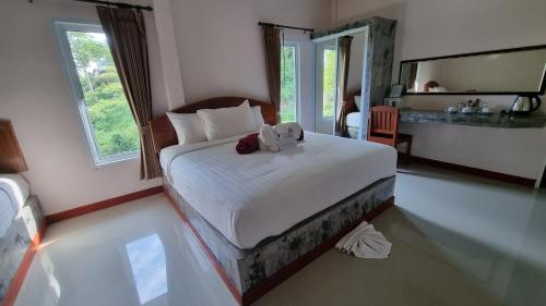 a bedroom with a bed with two teddy bears on it at PawPaw Resort in Koh Samui