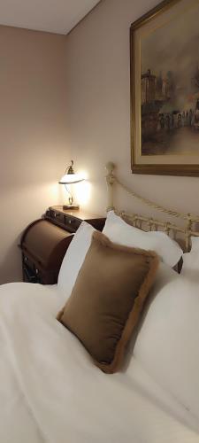 a bedroom with a bed and a picture on the wall at Αρχοντικό Ταξίμι (Μουντζουρίδη) in Argalasti