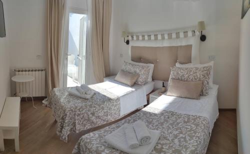 a small bedroom with two beds and a window at Il fiore di loto in San Felice Circeo