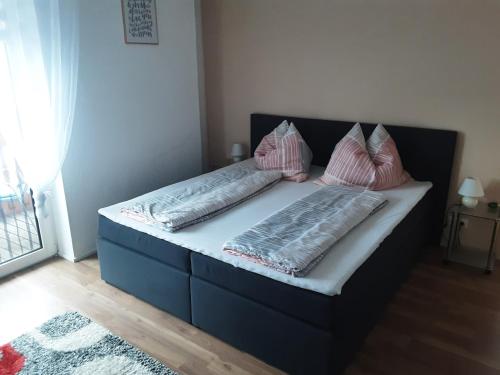 een bed met twee kussens in een kamer bij Apartment - Ferienwohnung 2 Treffen am Ossiachersee in Treffen