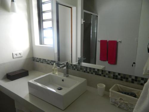 a white bathroom with a sink and a mirror at Modern Villa with service. Exceptional beach, private swimming pool in Roches Noires