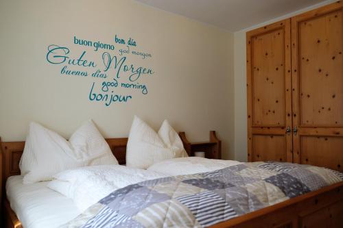 a bedroom with a bed with a sign on the wall at Gästehaus Reingruber in Ried im Traunkreis