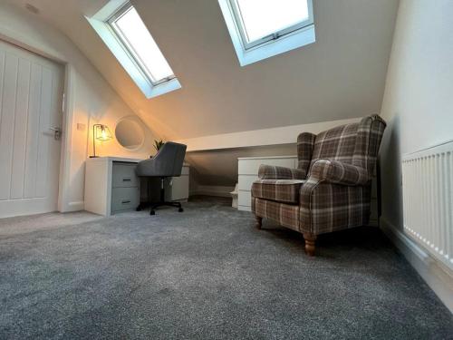 a room with a chair and a desk and skylights at The Hideaway Southport in Southport