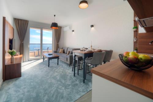 a living room with a kitchen and a dining room at Garden Recovery in Sveti Stefan