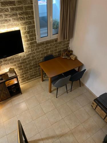 comedor con mesa, sillas y TV en Small cosy house Lavrion, en Lávrion
