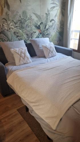 ein Bett mit weißer Bettwäsche und Kissen in einem Schlafzimmer in der Unterkunft Studio avec beaucoup de Charme intra muros in Avignon