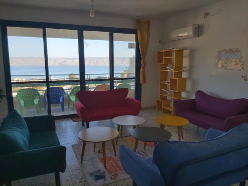 a living room with colorful furniture and a view of the ocean at turtle guesthouse- tiberias in Tiberias