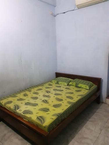 北加浪岸Hotel Griya Syar'i的黄色被子的房间里的一个床位