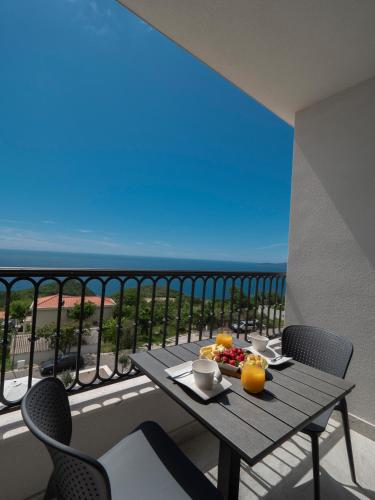 a table with fruit on it on a balcony at Garden Recovery in Sveti Stefan