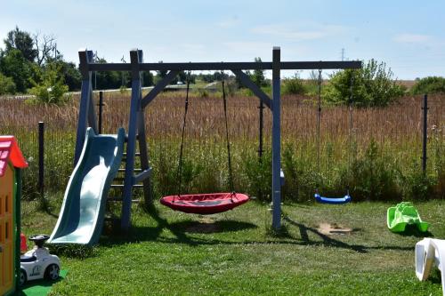 un parque infantil con toboganes y otros juguetes en el césped en BLASK LATARNl, en Niechorze