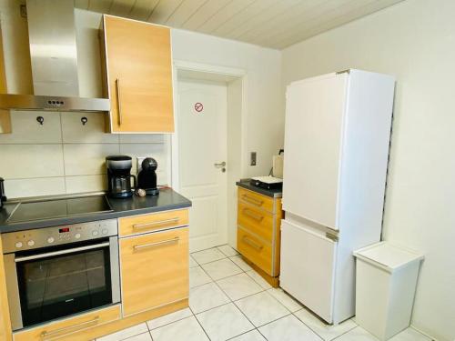 a kitchen with a white refrigerator and a stove at Ferienwohnung mit Talblick für Monteure in Kirschhausen