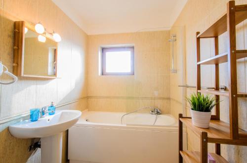a bathroom with a tub and a sink and a bath tub at Hotel Apart Tel Aviv in Sebeş