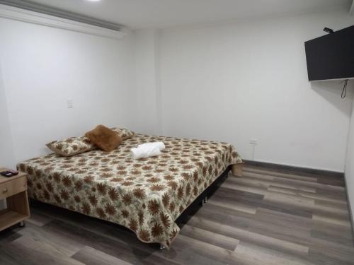 a bedroom with a bed with a brown and white blanket at Hermoso apartamento Medellín in Medellín