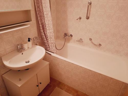 La salle de bains est pourvue d'un lavabo et d'une baignoire avec lavabo. dans l'établissement Le Cleuson - centré avec vue, à Nendaz