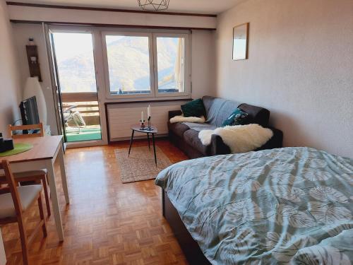 sala de estar con cama y sofá en Le Cleuson - centré avec vue, en Nendaz