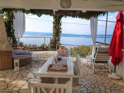 Un patio con mesa y sillas y vista al mar. en Guest House Lili, en Dramalj