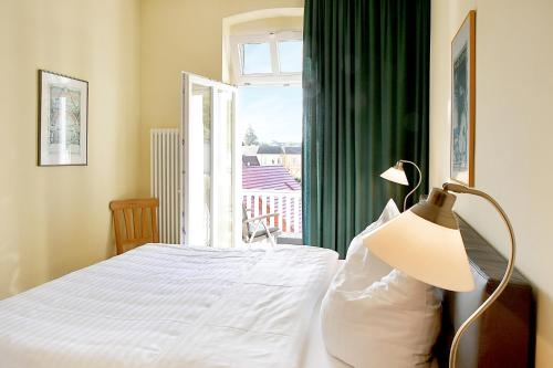 a bedroom with a bed with a window and a lamp at Hamburg-App-04 in Ahlbeck