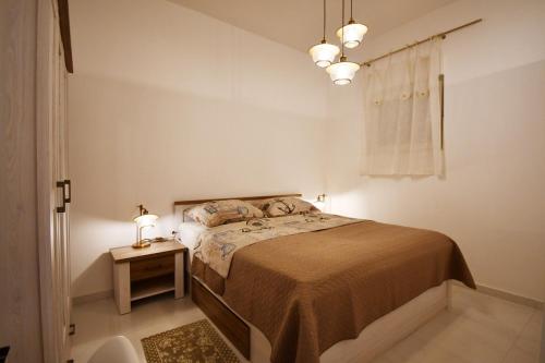 a bedroom with a bed and a table with a lamp at Apartment Frida Rab in Banjol