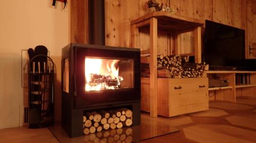 a fireplace in a living room with a fire in it at Zirbenchalet Obergruben in Brixlegg