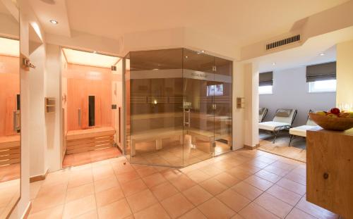 ein Bad mit einer Glasdusche im Zimmer in der Unterkunft Hotel Bianca in Lech am Arlberg