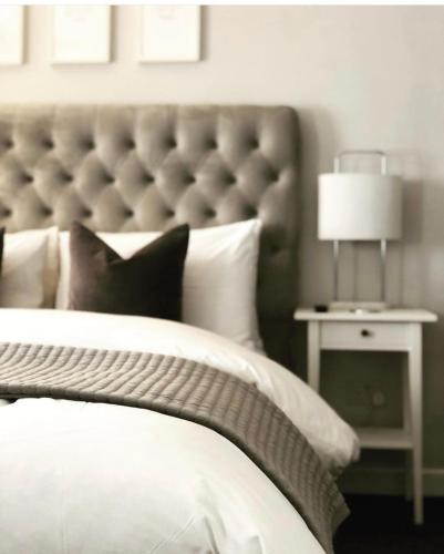 a bedroom with a white bed with a large headboard at Chadberry House Hotel in Blackpool