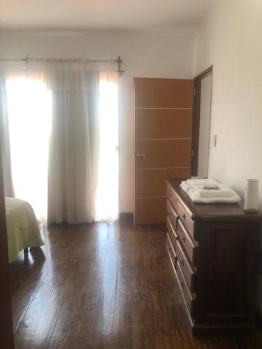 een kamer met een dressoir en een slaapkamer met een raam bij Alma costa in Posadas