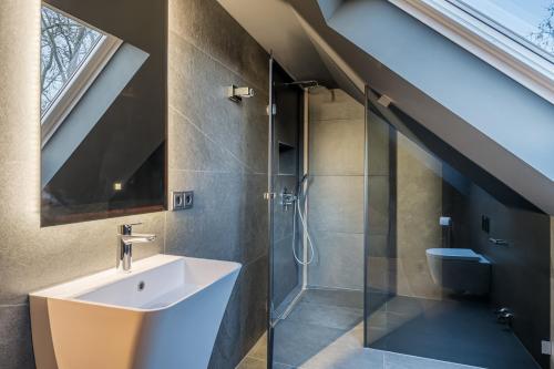 an attic bathroom with a sink and a shower at Sellmann´s Boutique Hotel in Dortmund