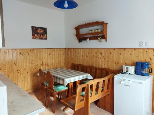 a kitchen with a table and chairs and a refrigerator at Sövényes Szálláshely in Barcs
