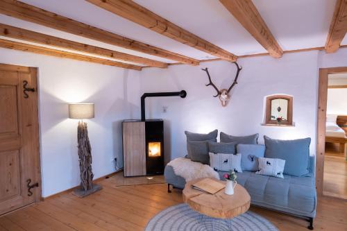 a living room with a blue couch and a wood stove at Landhaus im Allgäu in Halblech