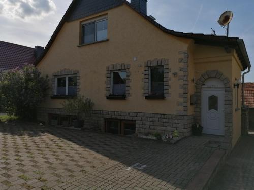 a brick house with a white door and windows at Doppelzimmer bei Ferienwohnung Kilian in Weberstedt
