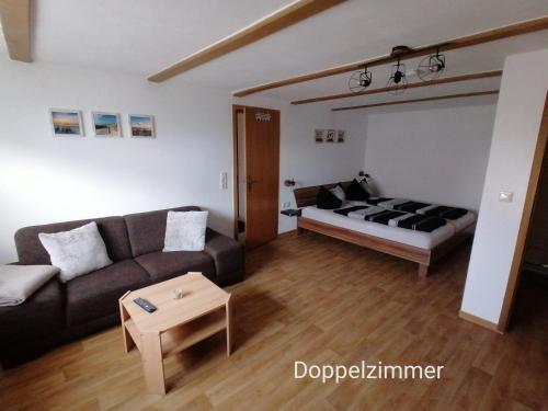 a living room with a couch and a bed at Doppelzimmer bei Ferienwohnung Kilian in Weberstedt