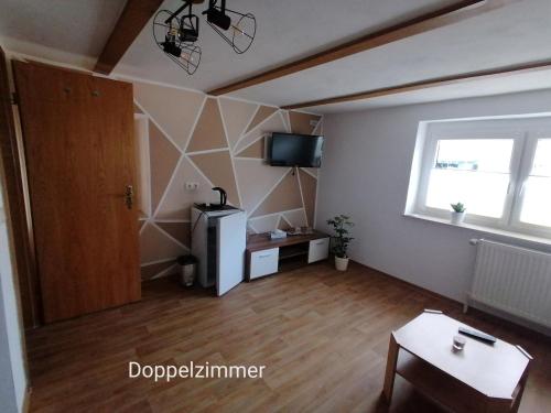 a living room with a wooden floor and a window at Doppelzimmer bei Ferienwohnung Kilian in Weberstedt
