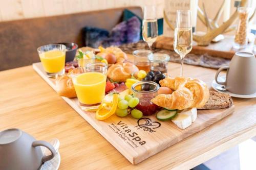 a table with a tray of food and glasses of orange juice at Chalet VitaSpa - Whirlpool & Sauna PrivatSpa in Pegnitz