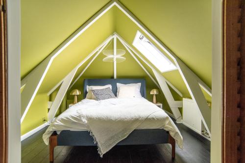 een slaapkamer met een bed met een driehoekig dak bij Uniek, slapen in De Graenkoper (De Rijp): 120 m2 in De Rijp