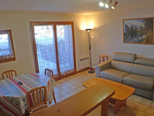 un salon avec un canapé et une table dans l'établissement Appartement Cosy 2 Pièces avec Terrasse - Résidence Le Marolie, Samoëns - FR-1-629-72, à Samoëns