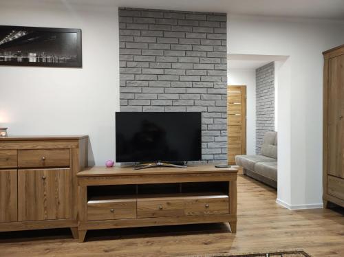 a living room with a television on a wooden entertainment center at Apartament Lago in Mrągowo