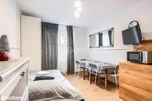 - une chambre avec une table et une salle à manger dans l'établissement LUKSUSOWY Gaj Apartament, à Wrocław