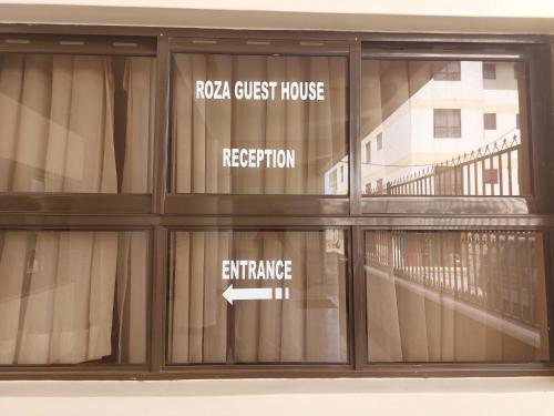 a glass window of a building with a sign that reads raega guest house reduction at Roza Guest House in Naivasha