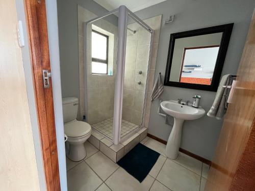 a bathroom with a shower and a toilet and a sink at 1One1@Boneyard in Jeffreys Bay